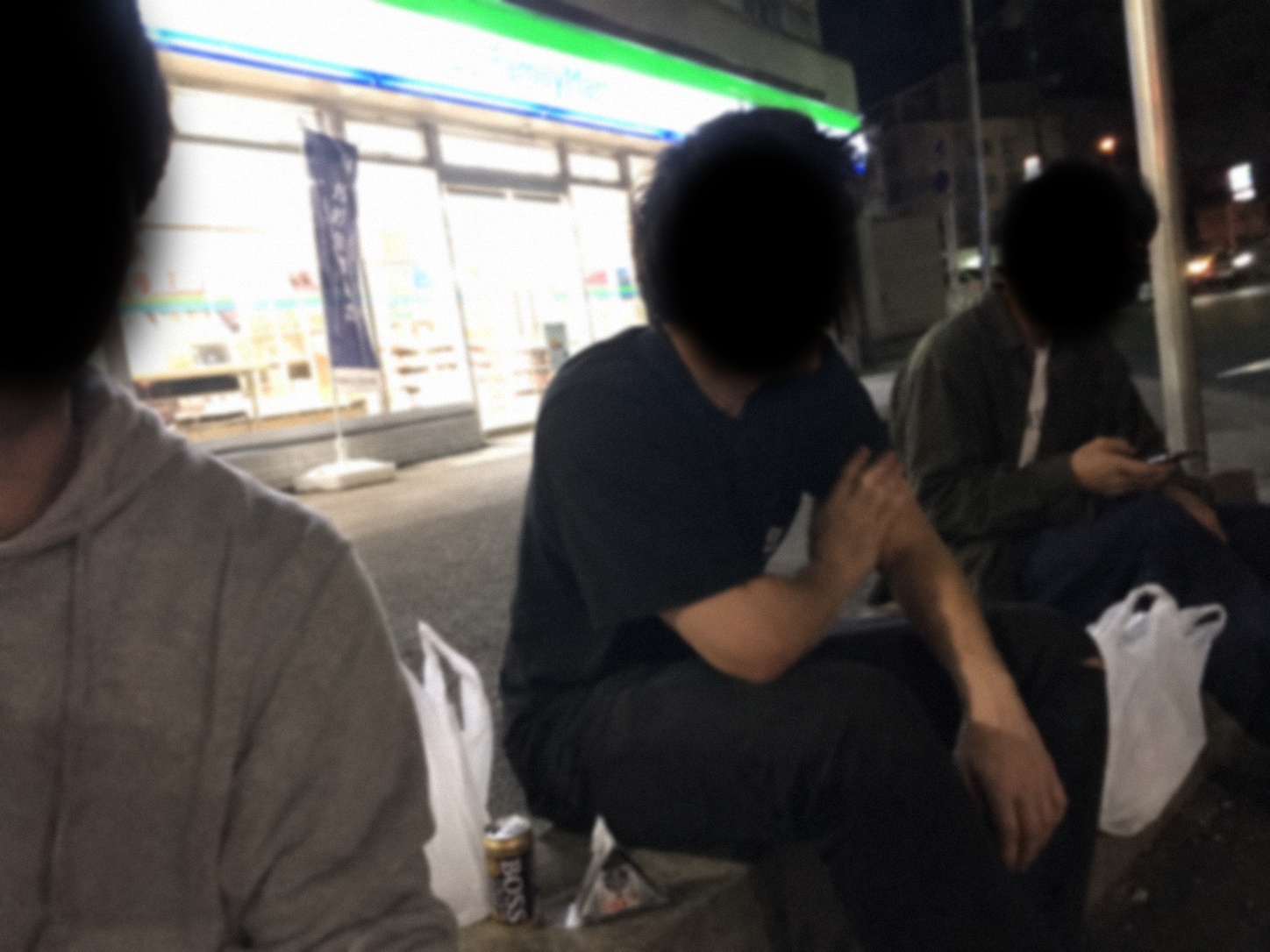 Three people sitting outside at night